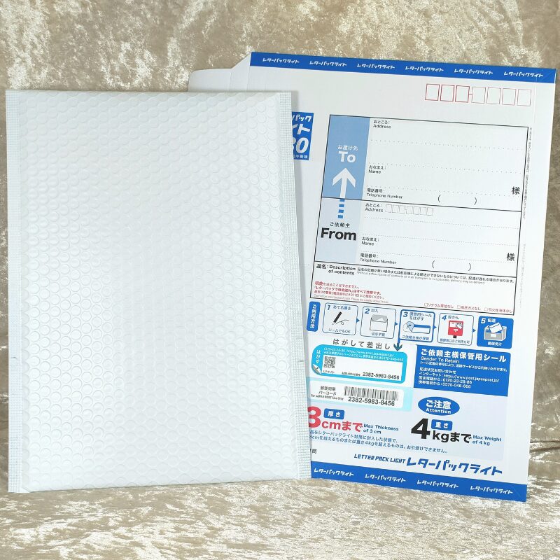 青いレターパックライトと、白いクッション封筒(緩衝材)が並べて置かれている様子